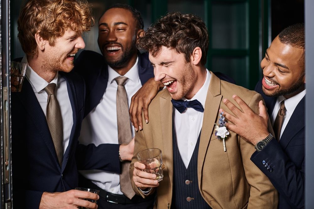 A group of men in suits and ties are standing next to each other and laughing.