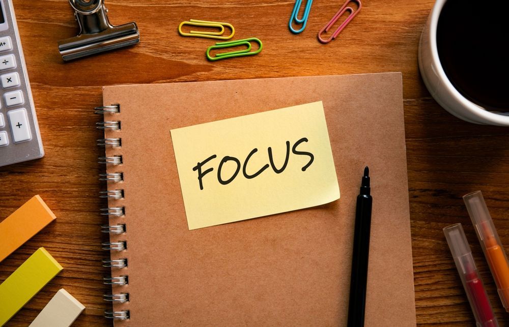 A notebook with a sticky note that says focus on it