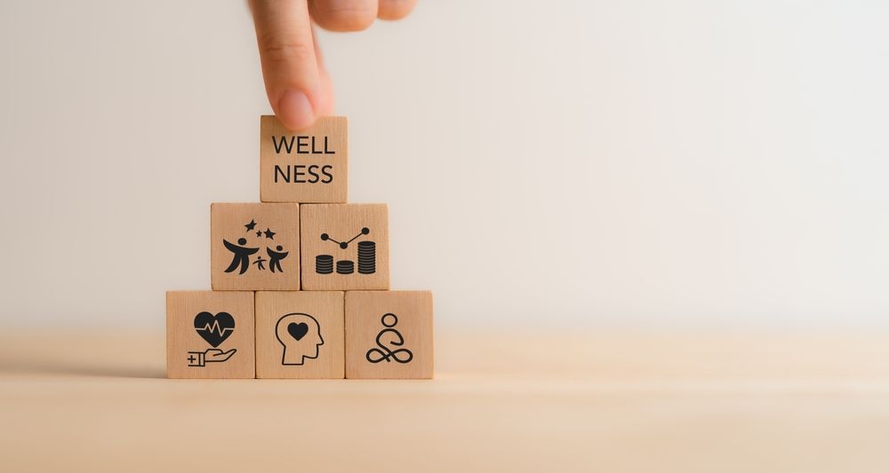 A person is stacking wooden blocks with icons on them.