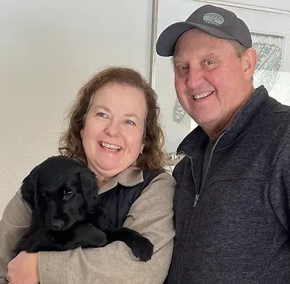 Happy couple with their new Highpoint Flatcoated Retriever puppy