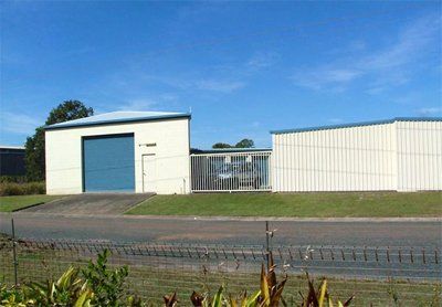 Buildings with blue doors and corrugated metal siding set against a clear, blue sky.