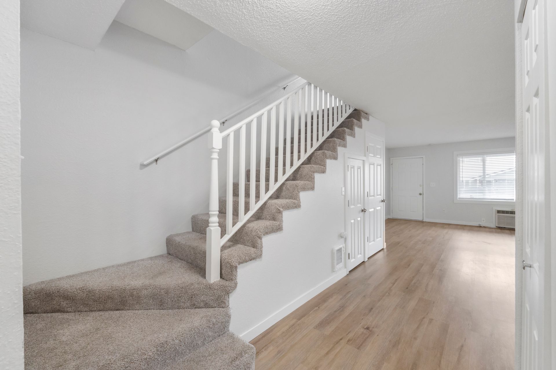 A hallway with stairs leading up to the second floor of a house.