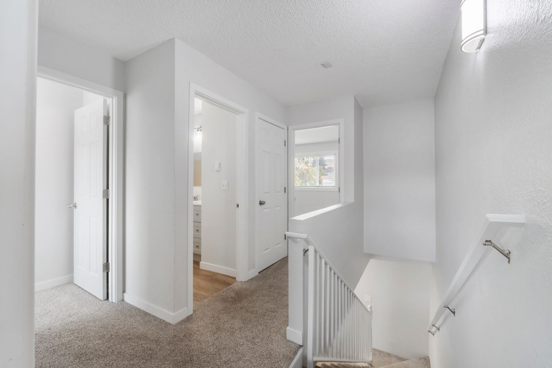 A hallway with stairs leading up to the second floor of a house.