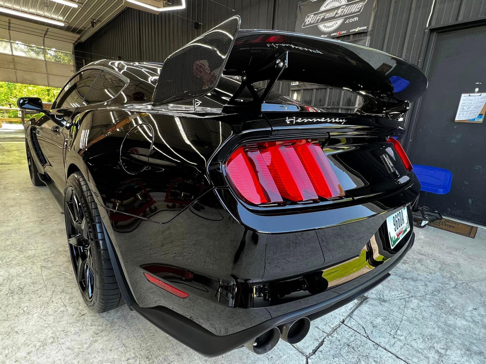 A black ford mustang is parked in a garage.