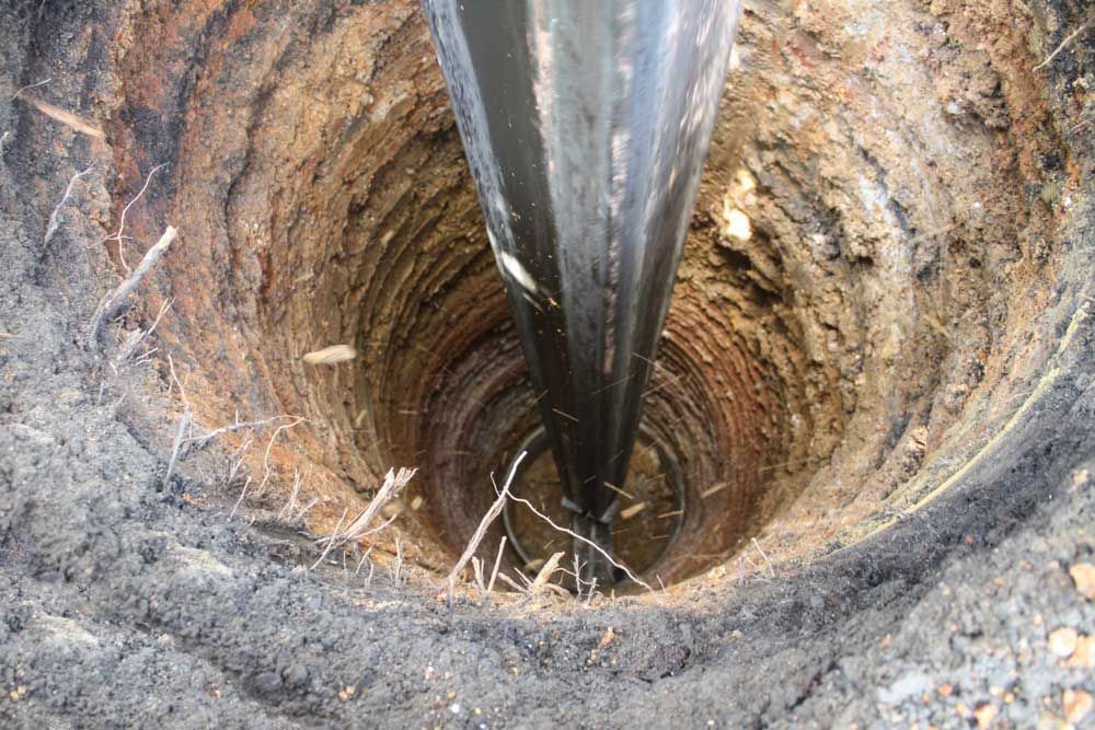 A Large Hole In The Ground With A Metal Pole Sticking Out Of It — Eureka Water & Filtration In Mount St John, QLD
