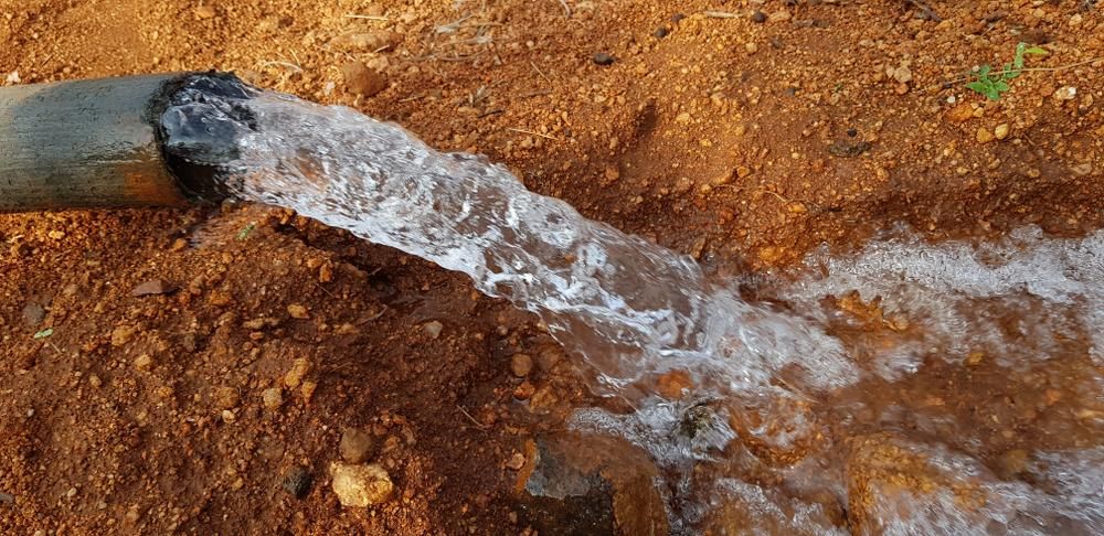 Water Is Coming Out Of A Pipe In The Dirt — Eureka Water & Filtration In Mount Isa, QLD