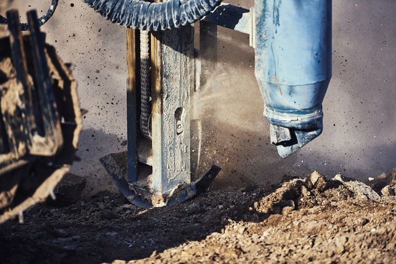 A Machine Is Digging A Hole In The Ground — Eureka Water & Filtration In Mount St John, QLD