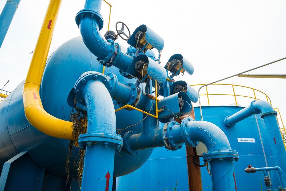A Bunch Of Blue Pipes Are Connected To A Large Tank — Eureka Water & Filtration In Mount St John, QLD