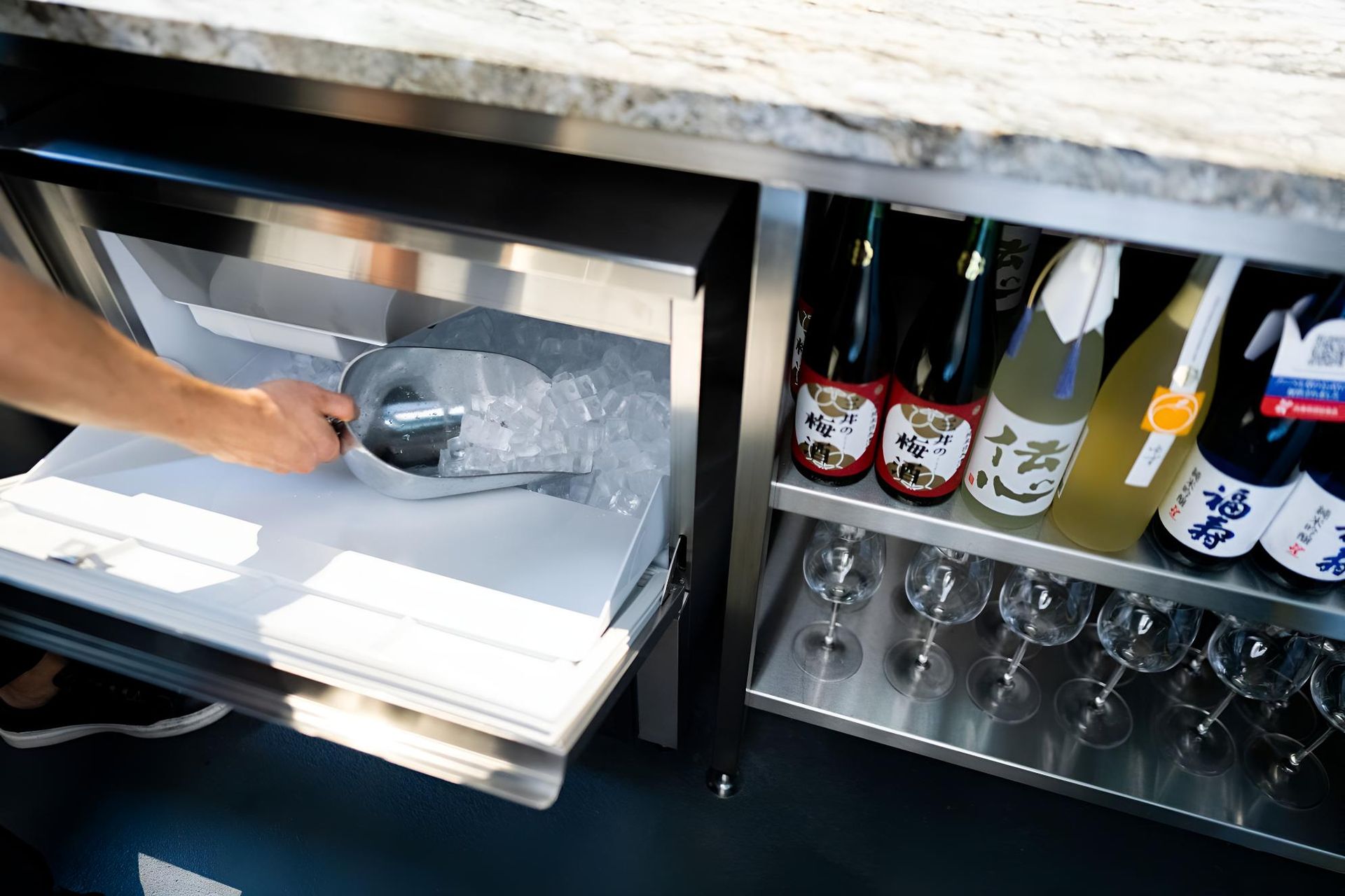 A Person is Scooping Ice From a Cooler in a Kitchen — Eureka Water & Filtration In Mount St John, QLD