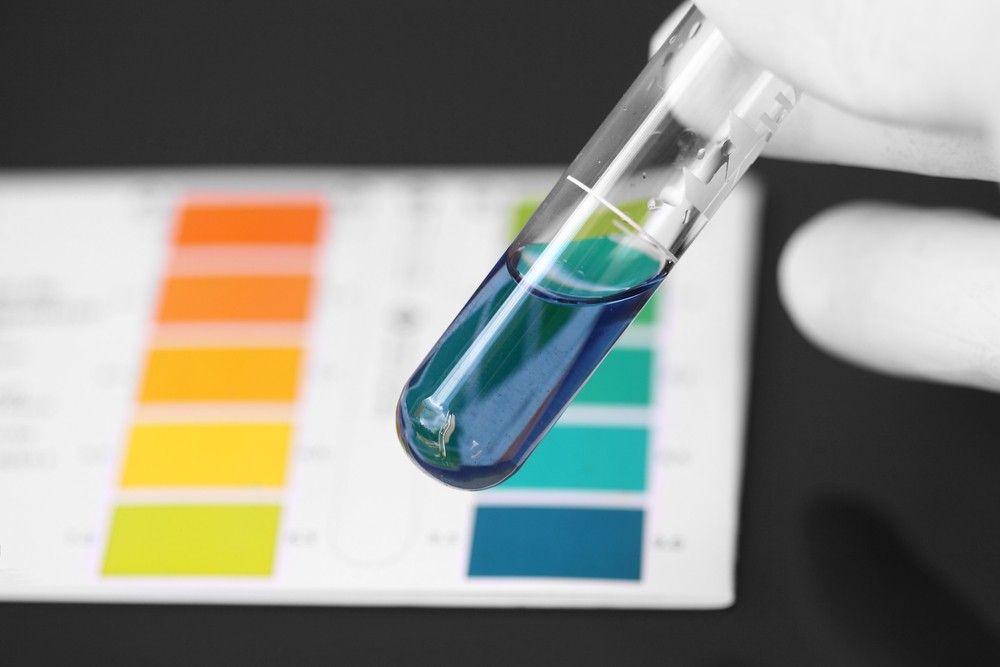 A Person Is Holding A Test Tube With A Blue Liquid In It — Eureka Water & Filtration In Cairns, QLD