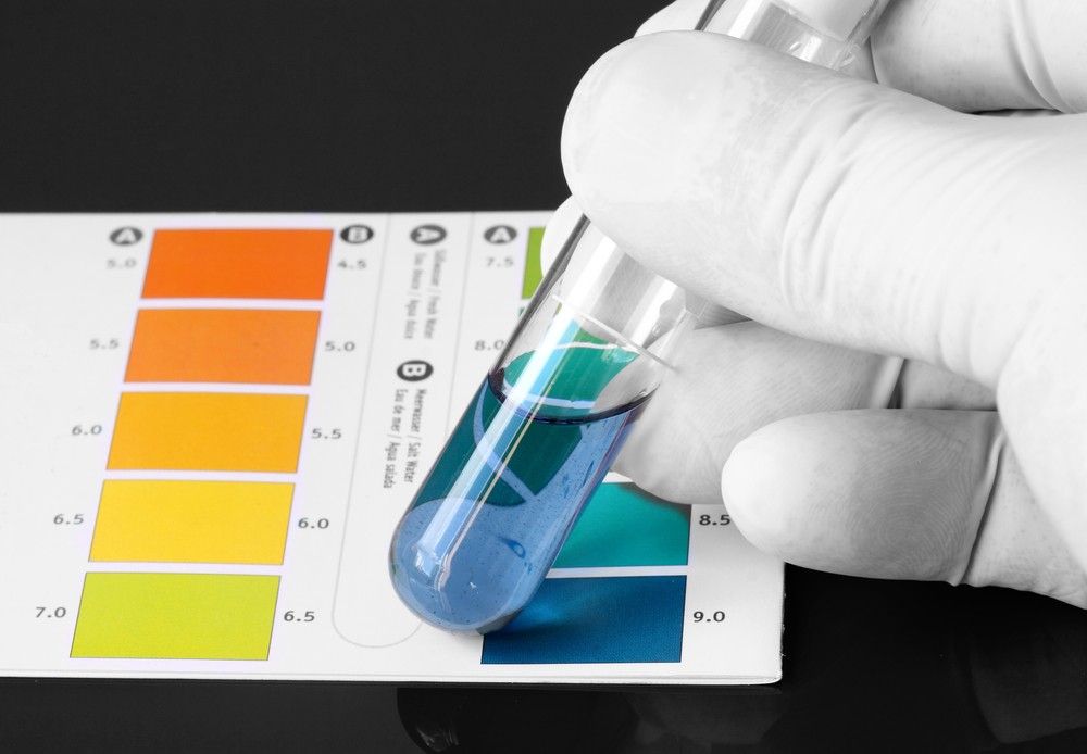A Person Is Holding A Test Tube With A Blue Liquid In It — Eureka Water & Filtration In Mount Isa, QLD