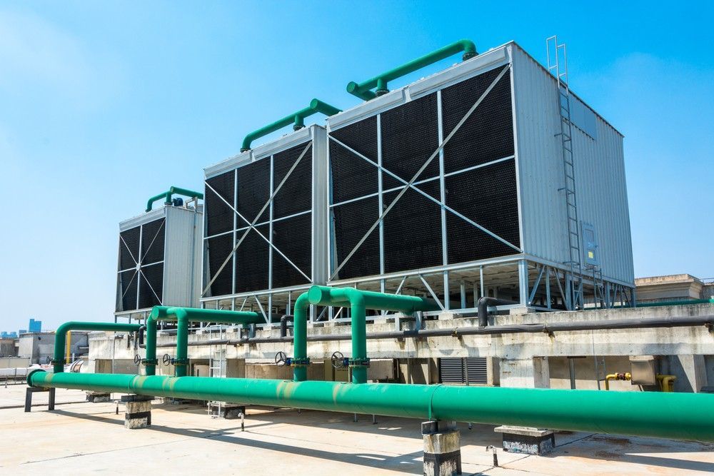 A Large Cooling Tower With Green Pipes Surrounding It — Eureka Water & Filtration In Mount Isa, QLD