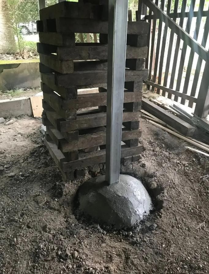 Wooden Post is Sitting in the Dirt Next to a Concrete Base — Wilson's House Restumping in Goonellabah, NSW