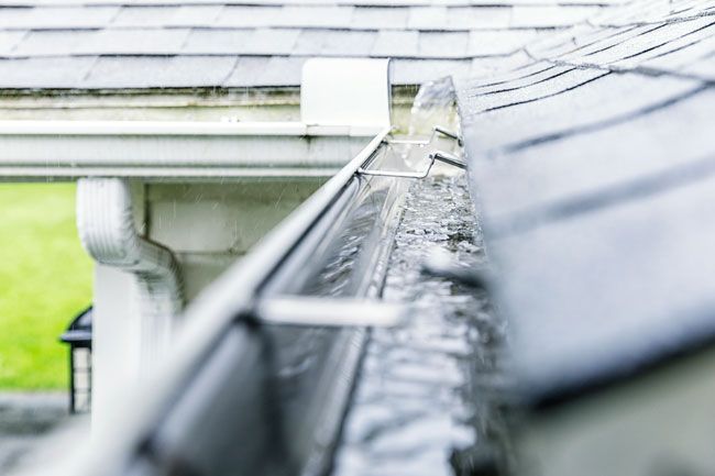 A close up of a gutter on a roof of a house.