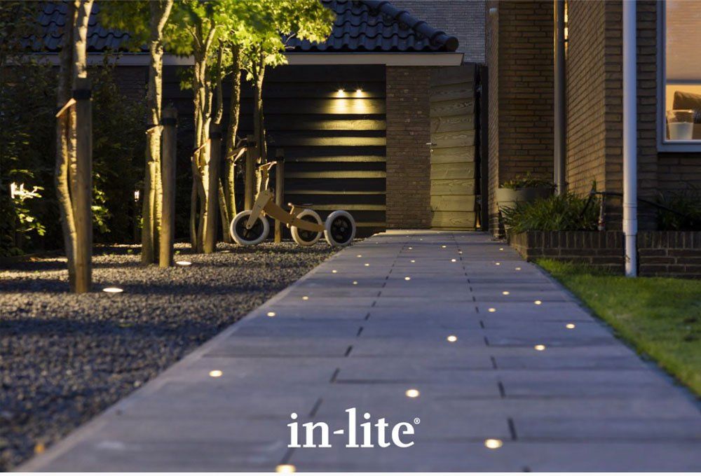 A row of lights in a garden with the words in lite on the bottom. landscape lighting.