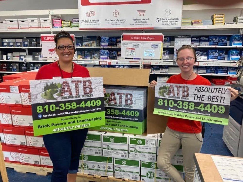 Two women are holding signs in a store that say absolutely the best