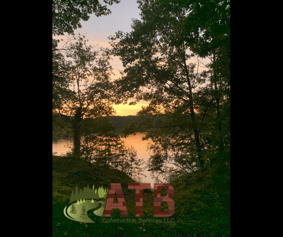 A picture of a sunset over a lake with atb construction services written on the bottom