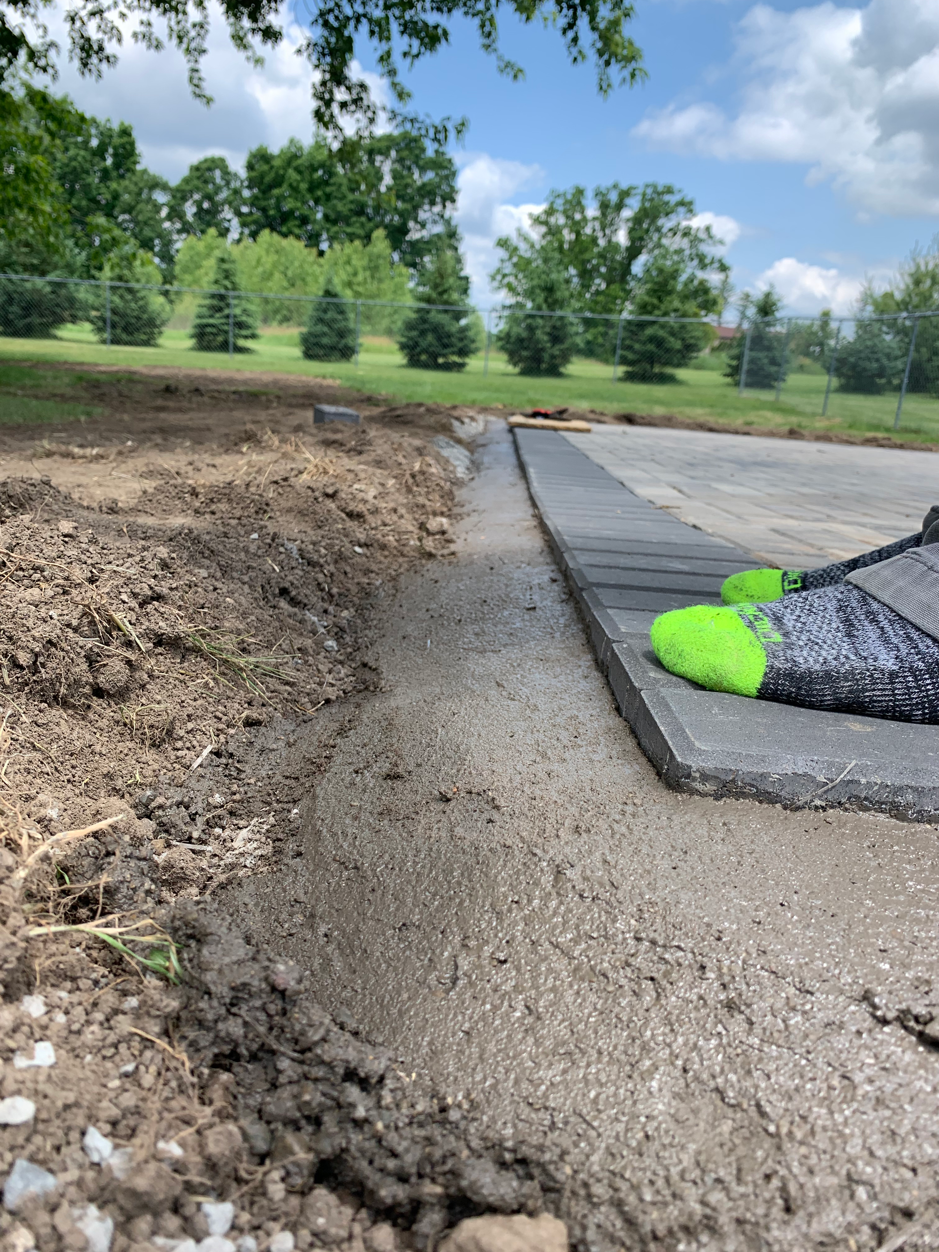 A concrete curb is being installed in a park.