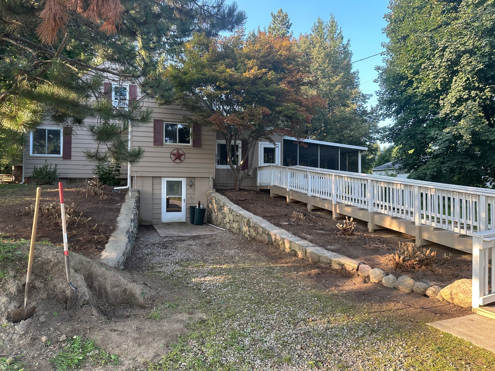 A house with a white fence and a ramp leading to it.