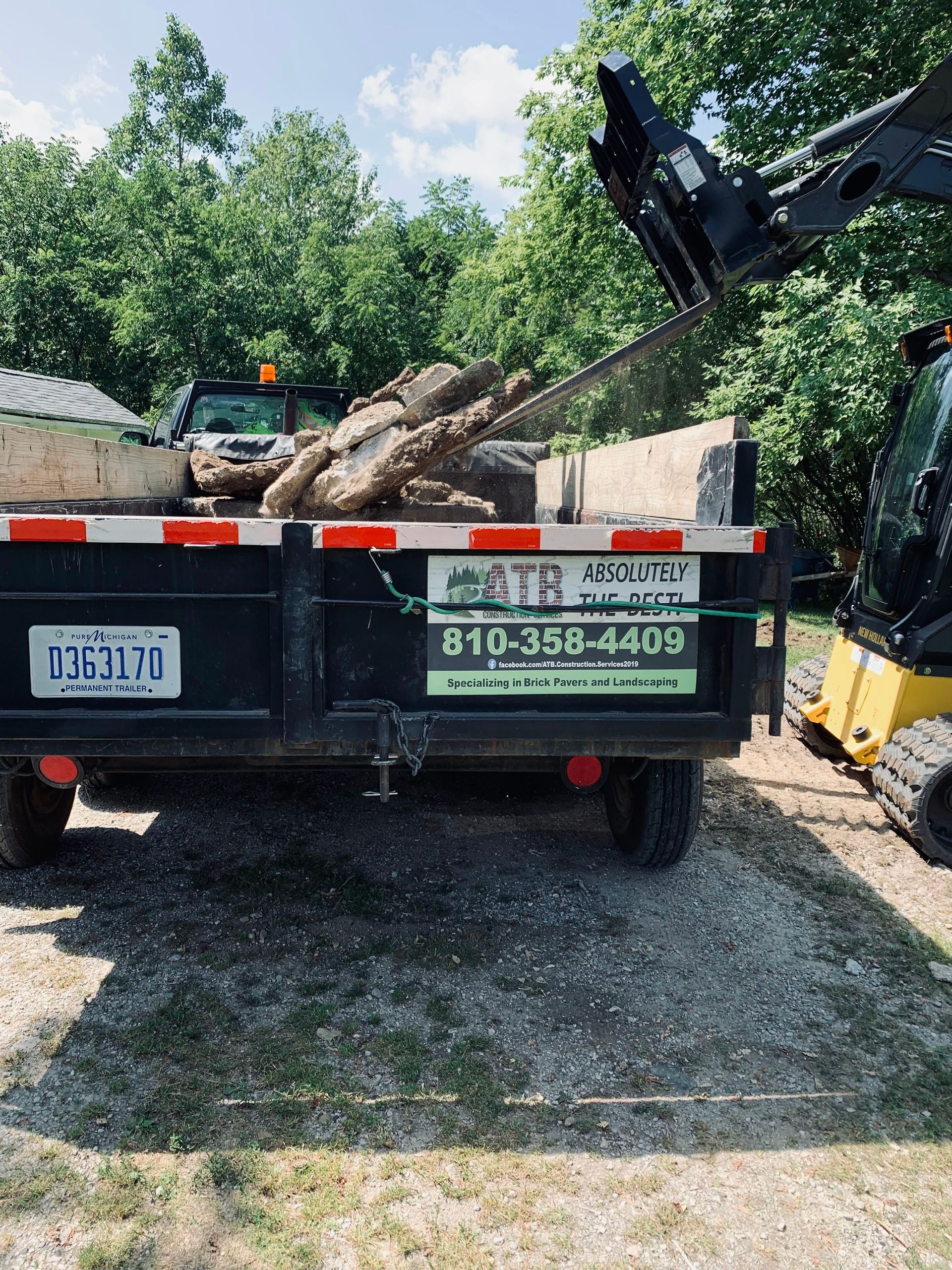A dump truck is being loaded with logs by a crane. demolition