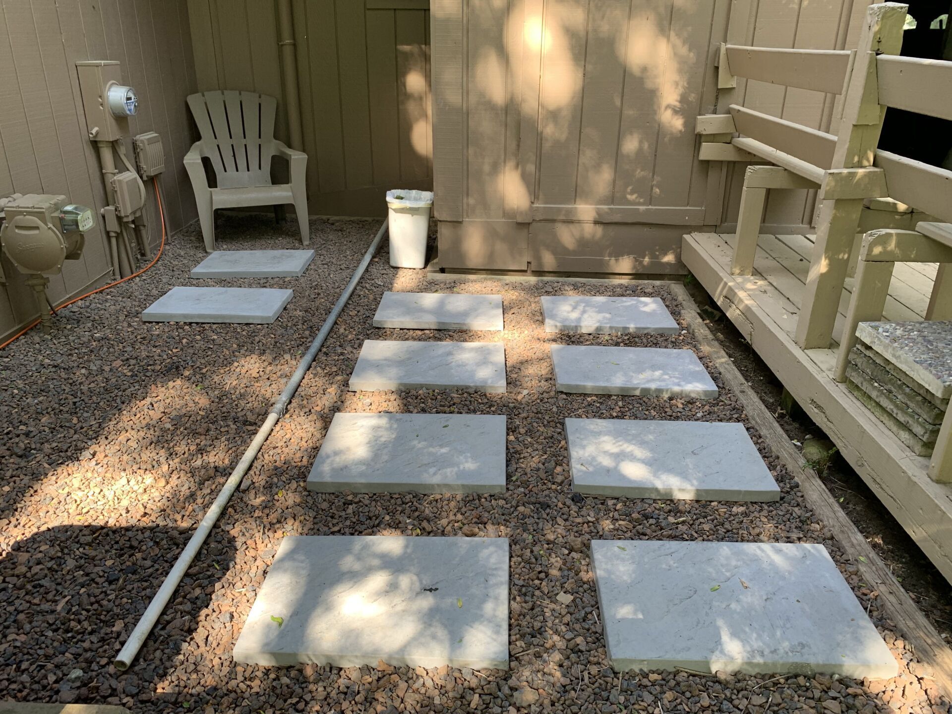 A pallet of bricks is sitting on the sidewalk in front of a house. bricks and block.