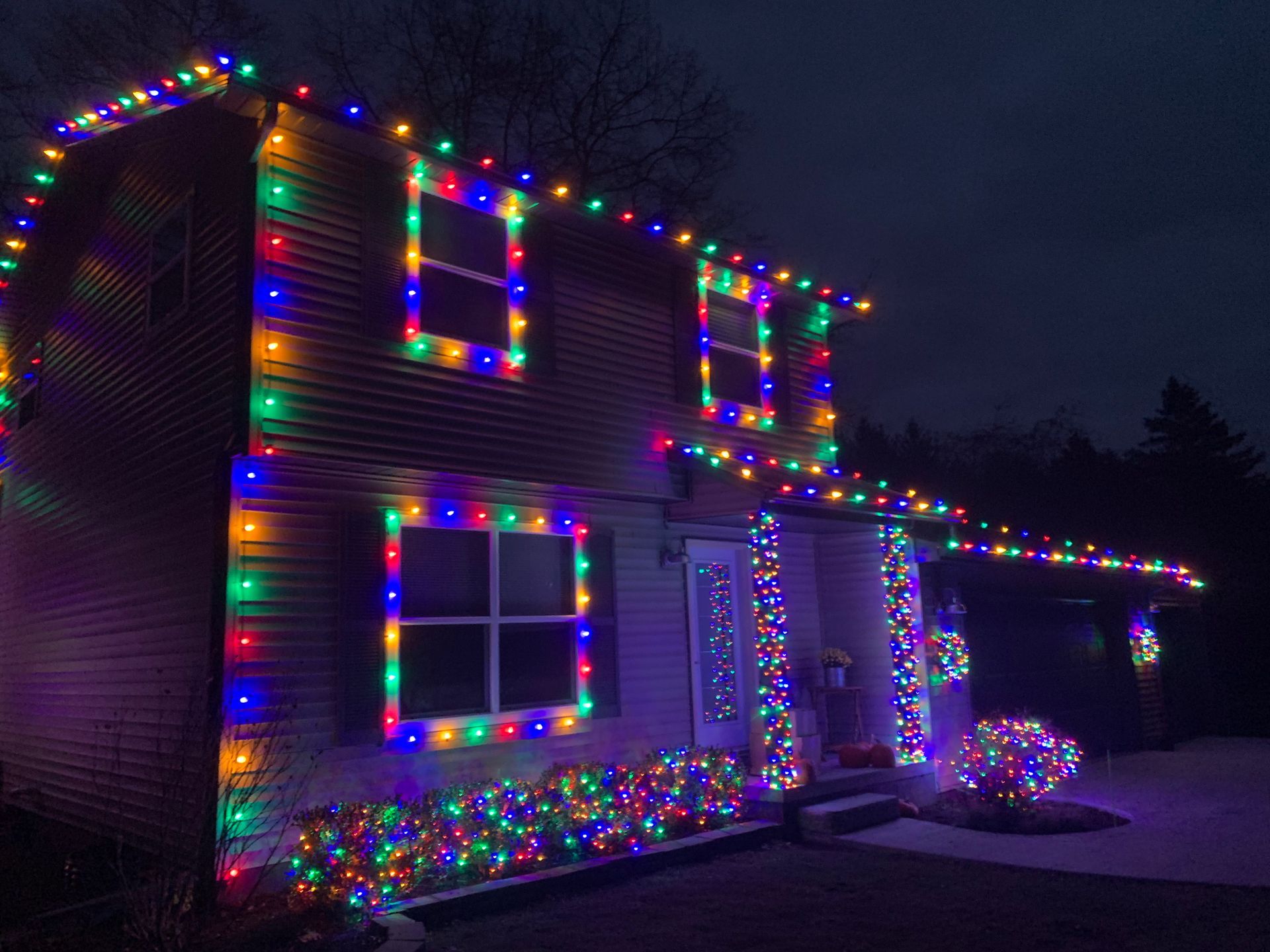 A house decorated with christmas lights is lit up at night. lights