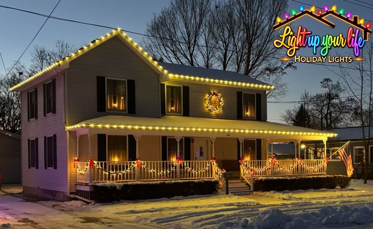 Warm white Christmas lights on roofline. high peaks. wreath. warm white lighting. garland. bows. Fenton Michigan light installation 