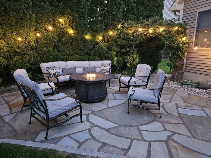 There is a fire pit in the middle of the patio. FLAGSTONE. OUTDOOR LIVING. 
