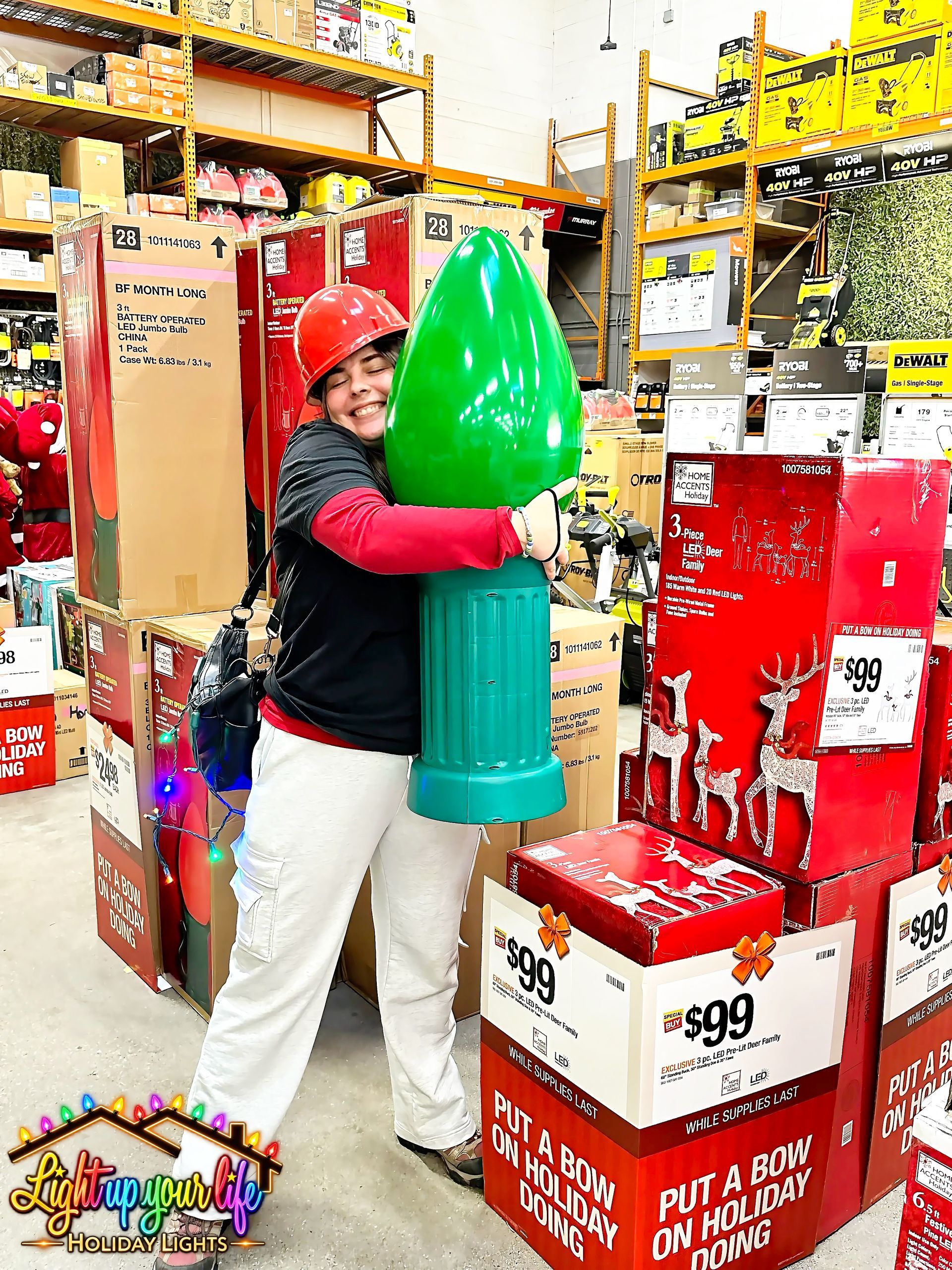 Lindsay lights hugging a large Christmas bulb that light up your life now uses as safety cones on the job. 