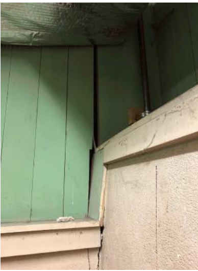 Corner of a room with green insulated walls and a white ledge, possibly a basement.