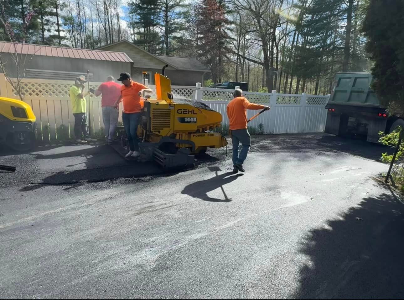 A group of men are working on a driveway.