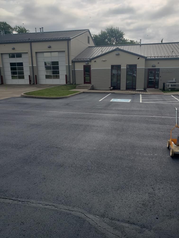 A small vehicle is parked in a parking lot in front of a building