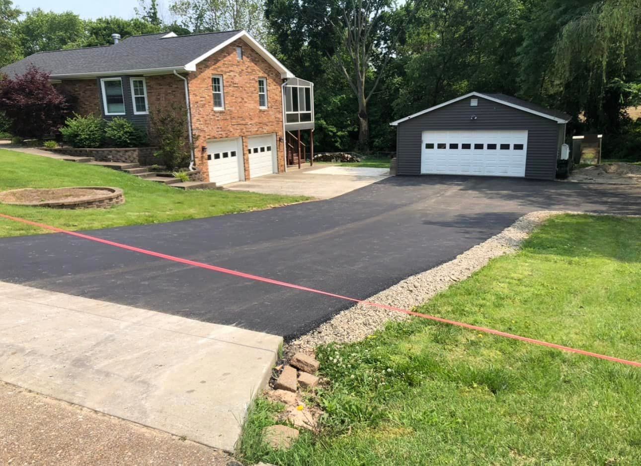 A house with a garage and a driveway in front of it.