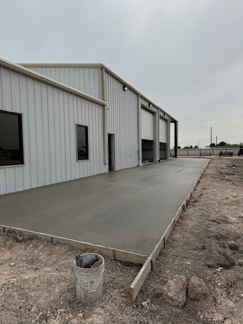A large white building with a concrete driveway in front of it.