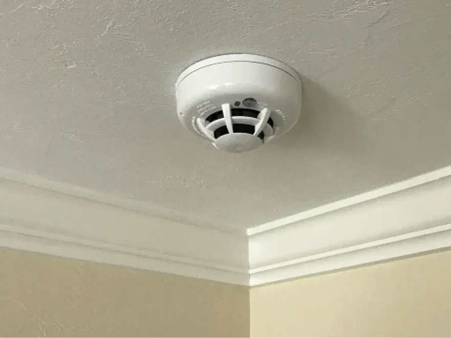 a man on a ladder fixing a ceiling fan