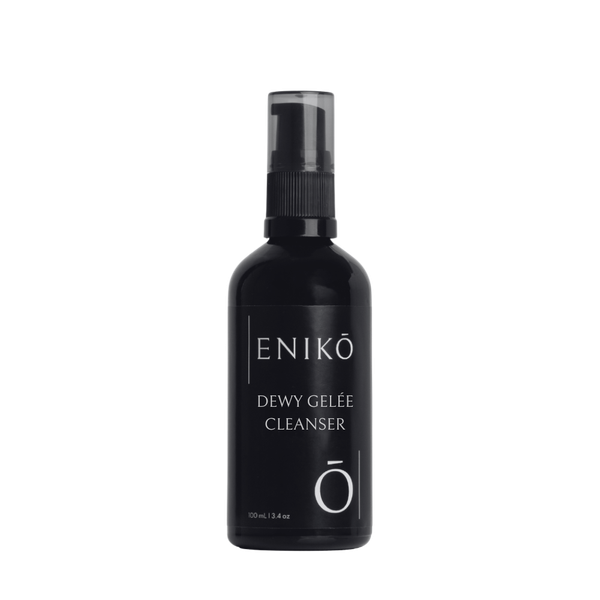 ENIKŌ Dewy Gelée Cleanser, a lightly foaming cleanser in a black glass pump bottle.