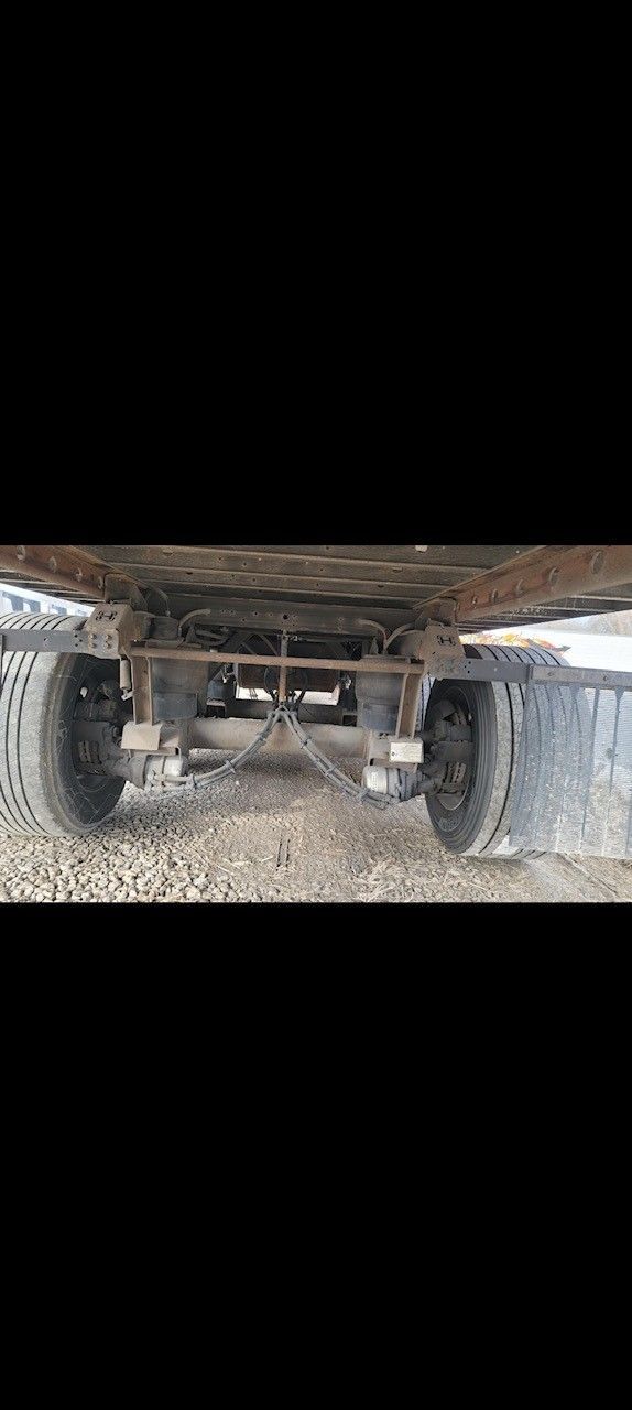 Undercarriage of a vehicle with two rear tires and suspension components.