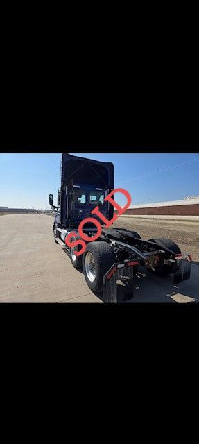 Black semi-truck on asphalt, with 