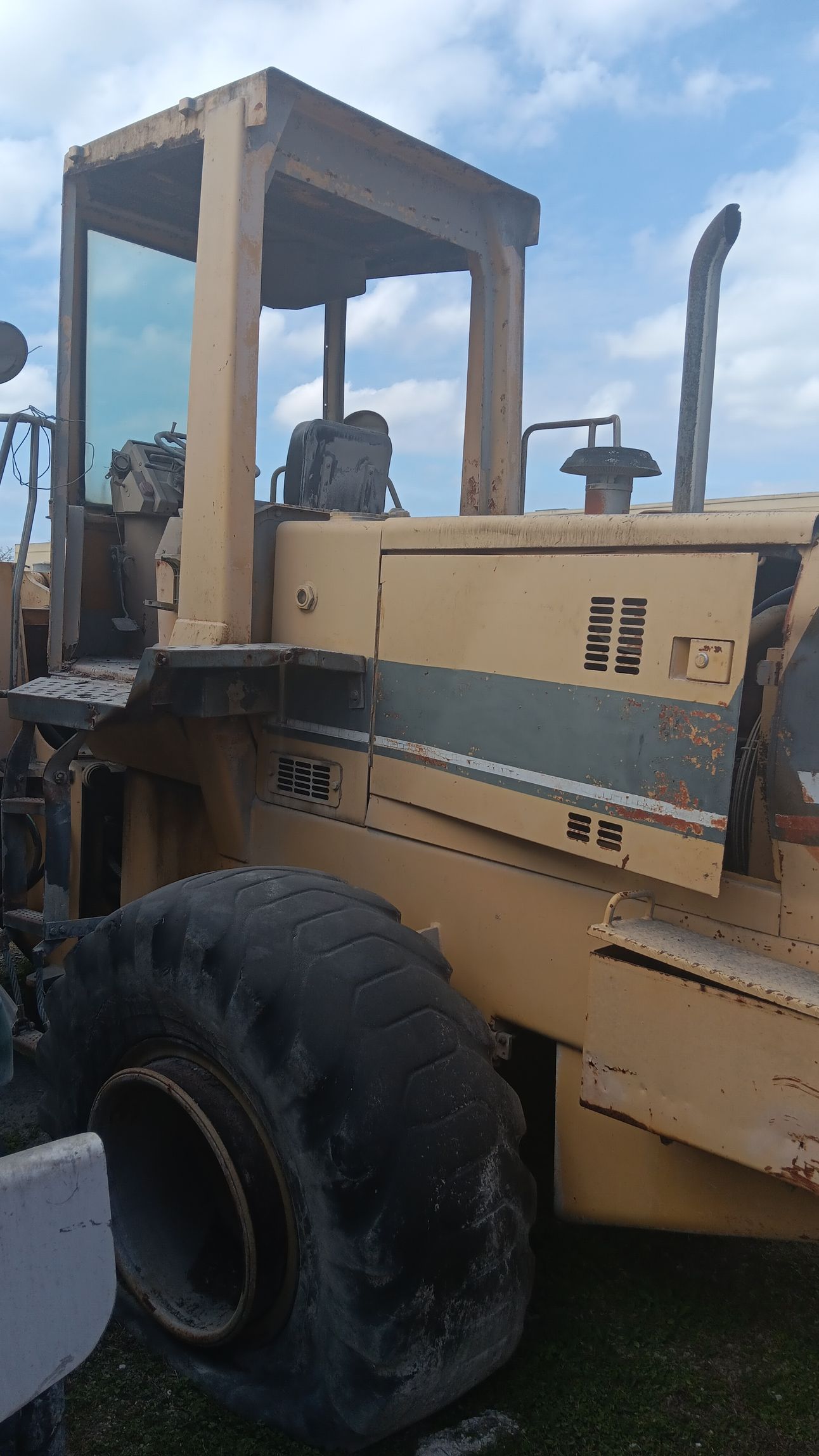 Yellow heavy construction compactor, outdoors, sunny day.