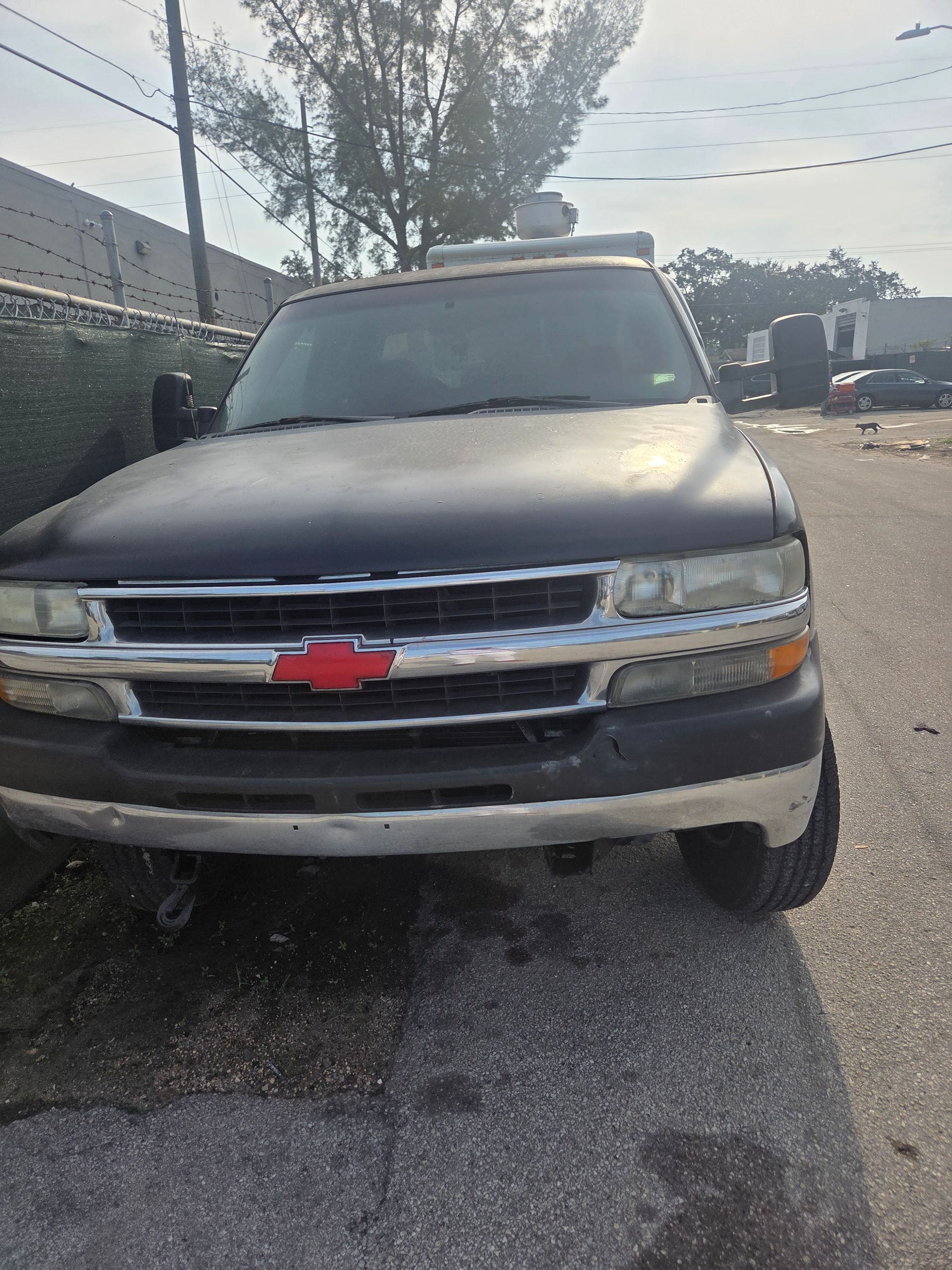 Black Chevrolet truck parked on asphalt. Red bowtie emblem on grill.