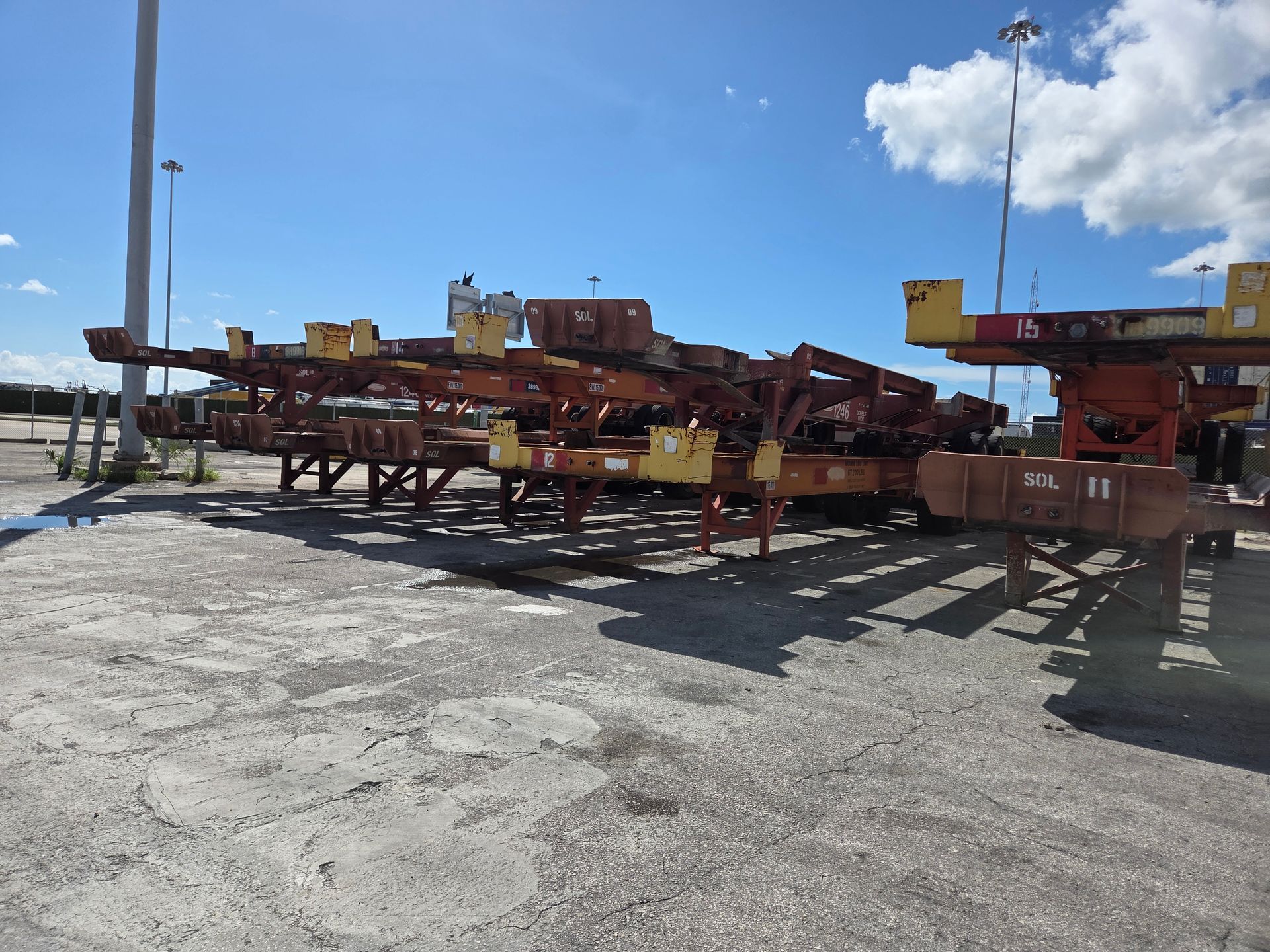 Empty shipping container chassis parked outdoors on a sunny day.