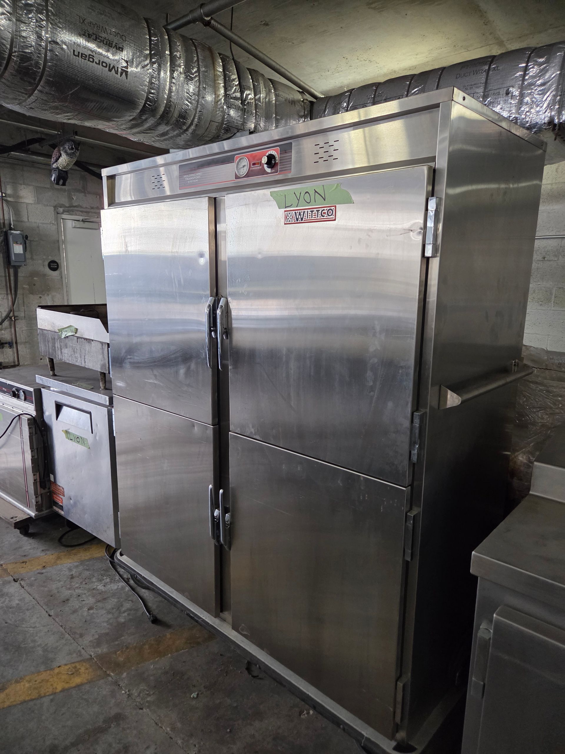 Stainless steel commercial double-door refrigerator in a kitchen setting.
