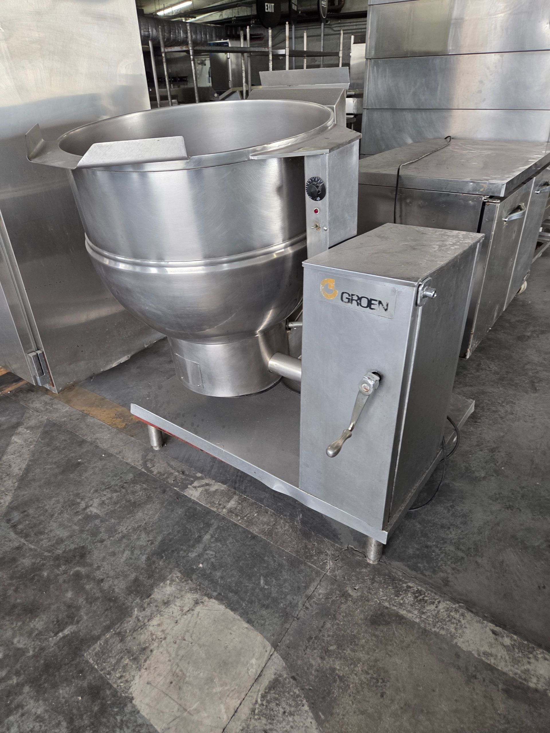 Stainless steel commercial tilting braising pan in a kitchen.