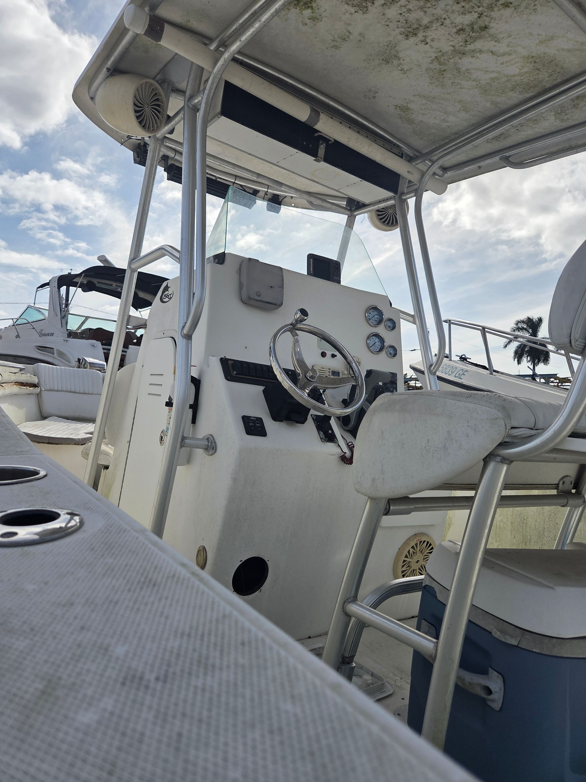 White boat interior with steering wheel and control panel.