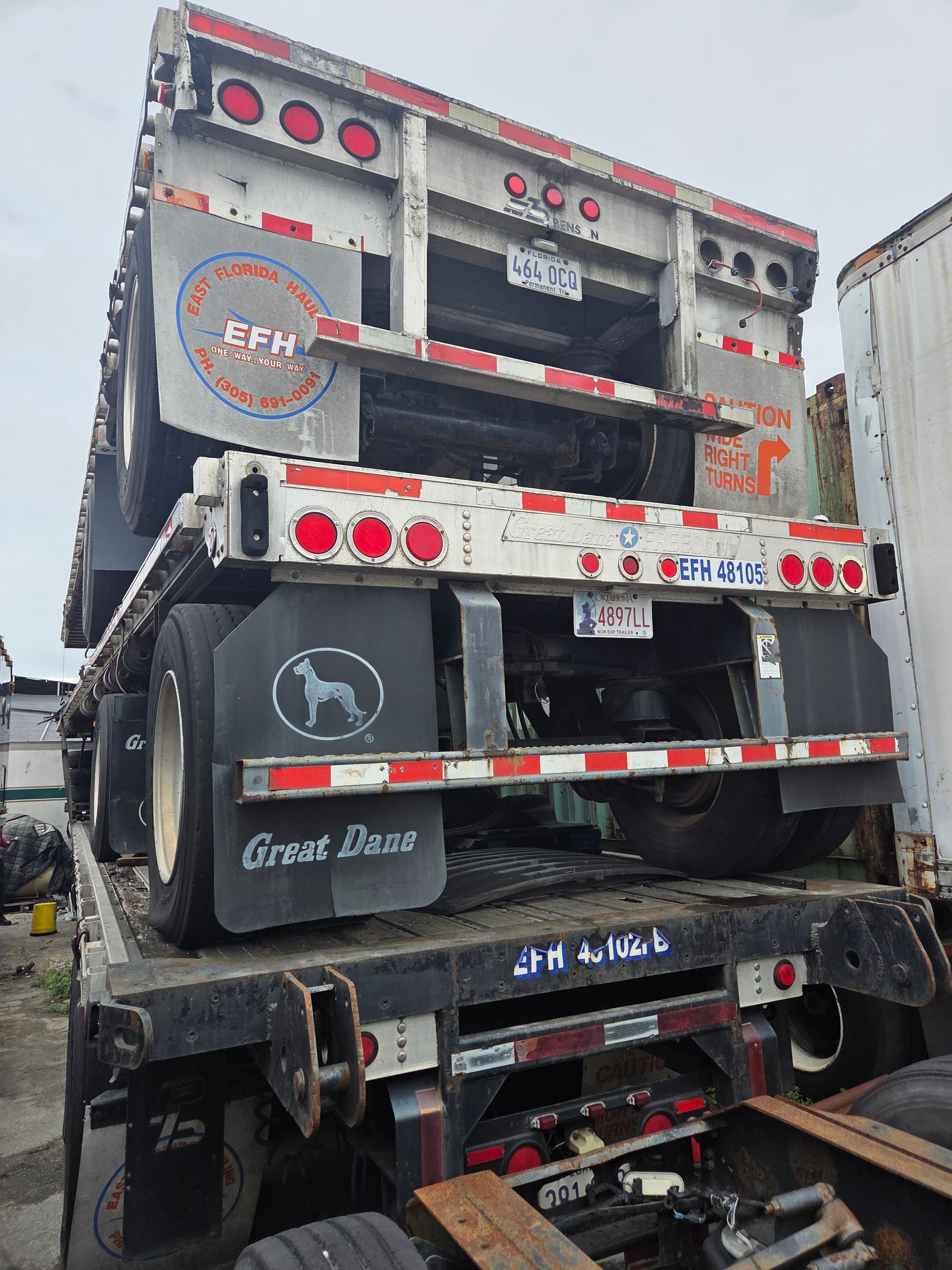 Two semi-truck trailers stacked on top of each other outdoors. One is labeled 