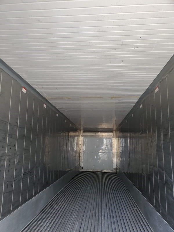 Interior of a refrigerated semi-trailer, with metal walls, ceiling, and ribbed floor.