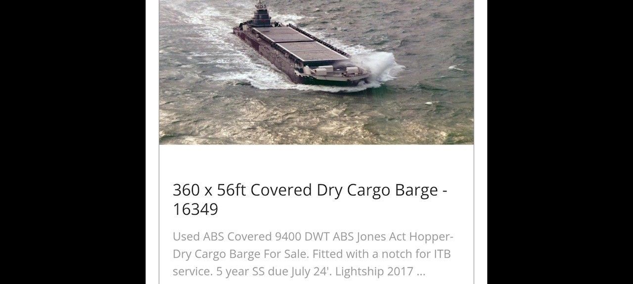 A dry cargo barge traveling on water.