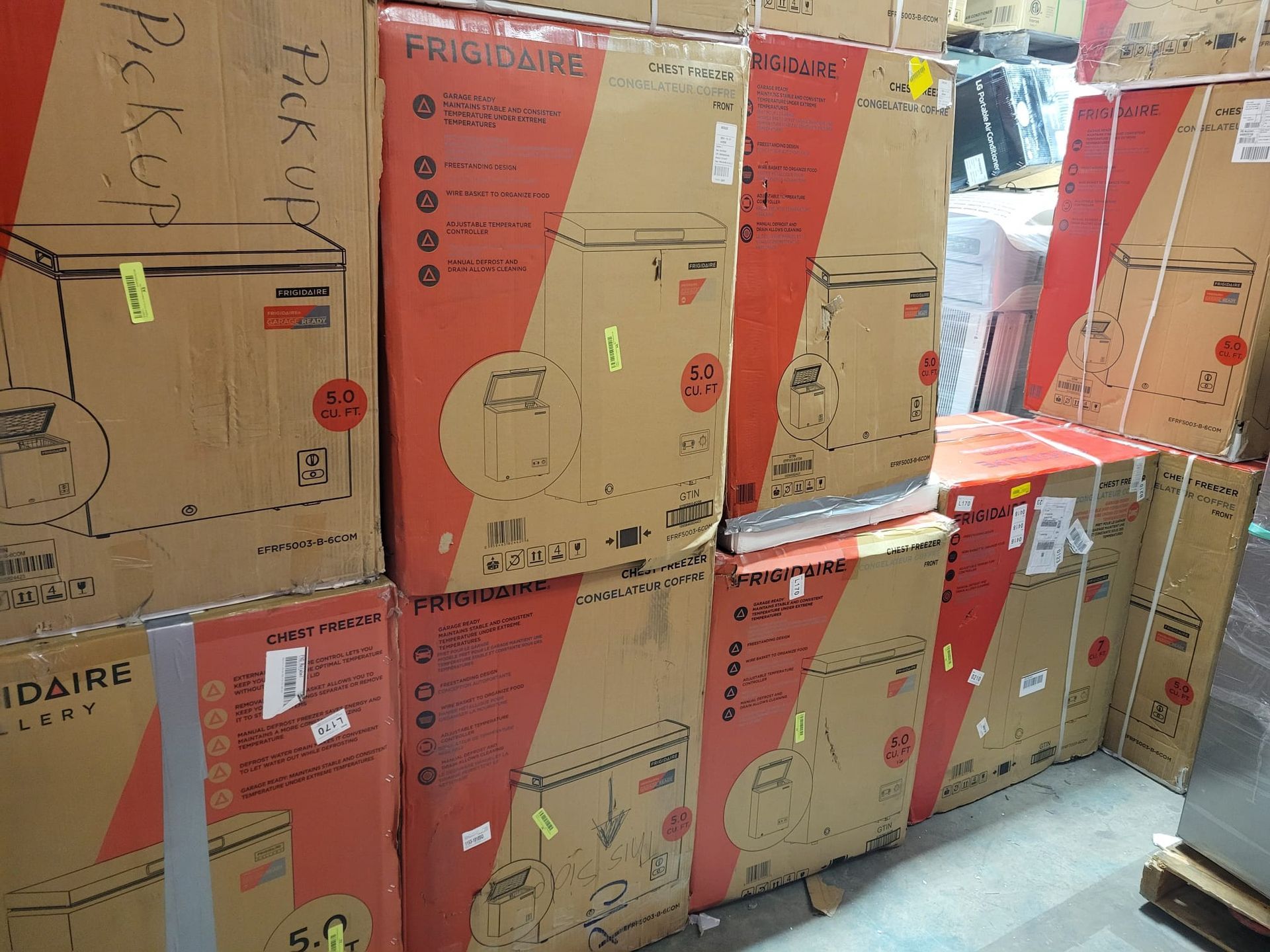 Brown cardboard boxes of Frigidaire appliances stacked in a warehouse.