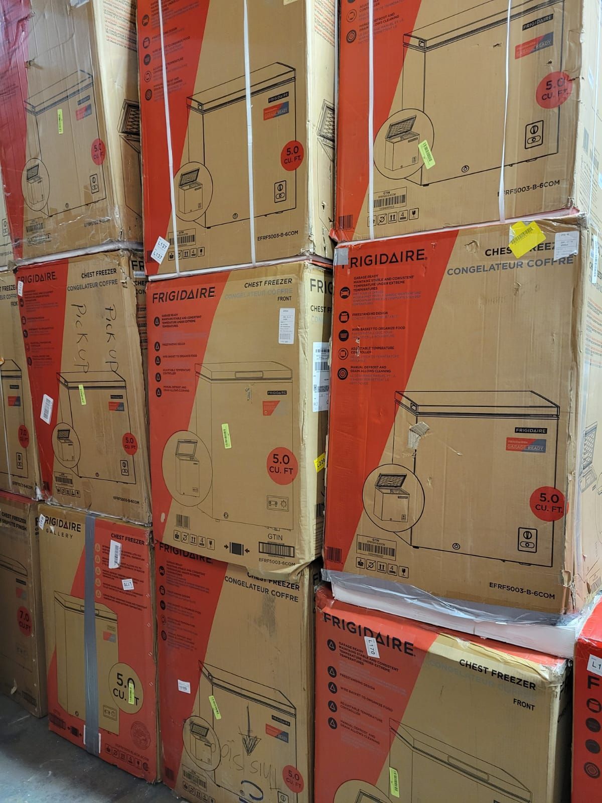 Stacked cardboard boxes of freezers, with red and white branding.
