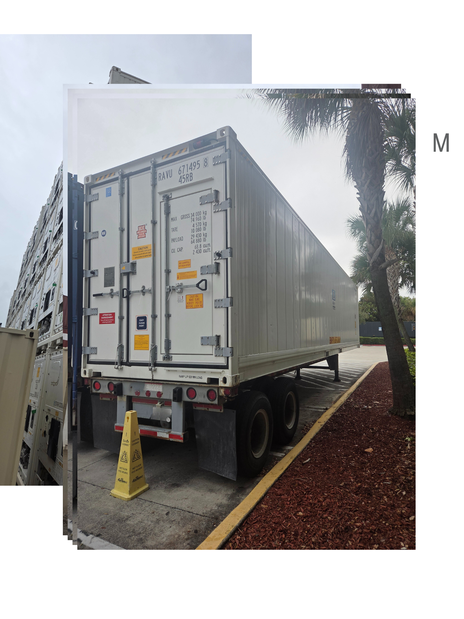 White semi-trailer parked near a tree, with door open and traffic cone.